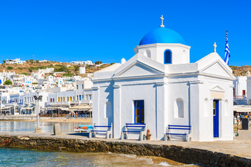 Typical Greek white church building with blue dome in Mykonos port, Mykonos island, Cyclades, Greece