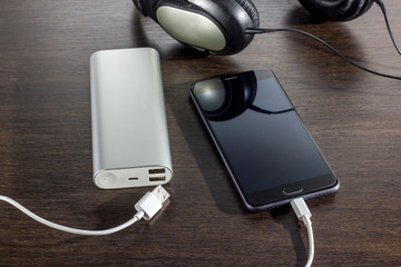 mobile phone and power bank battery on dark background
