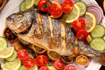 Grilled fish and vegetables on the plate