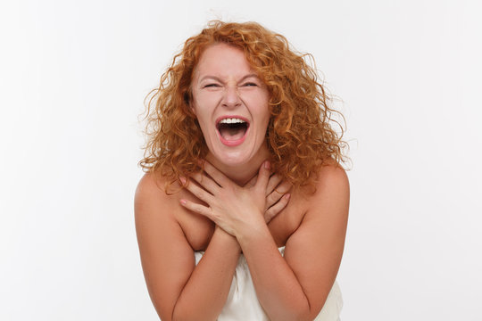 Picture of screaming or shouting mature woman isolated on white. Red haired woman posing for photographer in studio. Expressing emotions concept.