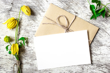 bouquet of yellow flowers with blank white greeting card and envelope