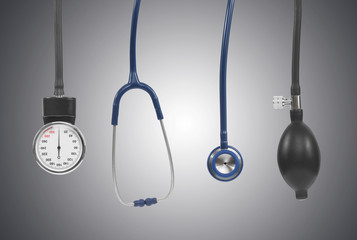 Blood pressure measuring instruments including stethoscope on grey background