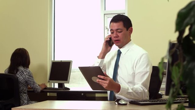 Office worker using tablet and cellphone