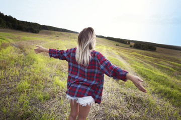 Young girl spreading hands with joy and inspiration facing the sun