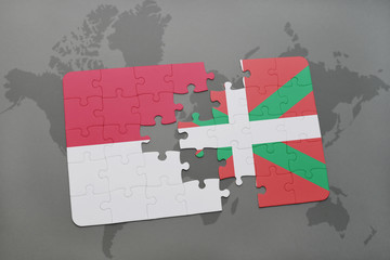 puzzle with the national flag of indonesia and basque country on a world map background.