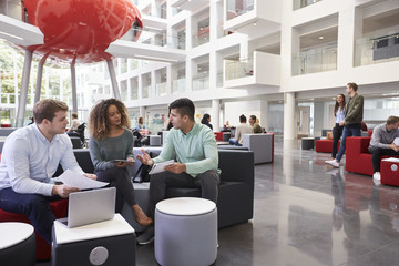 Students in university atrium, three in foreground close up