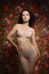 Fototapeta premium Beautiful sensuality girl on a flower wall background