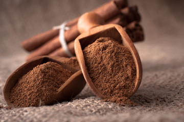 ground cinnamon spice powder in wooden spoon