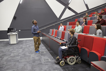 Man lecturing students in a university lecture theatre