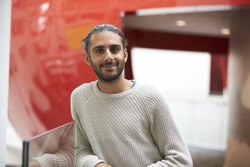 Asian male student in modern university building, portrait
