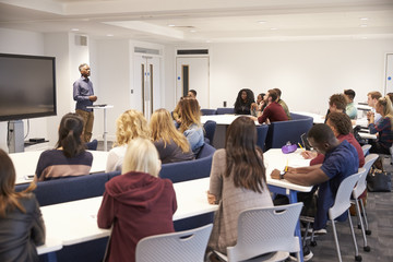 Fototapeta University students study in a classroom with male lecturer obraz