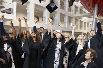 University students throwing their caps in the air on graduation