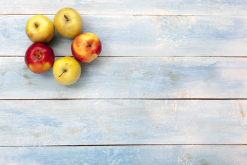 Naklejka na ściany i meble Apples on a blue wooden board, top view
