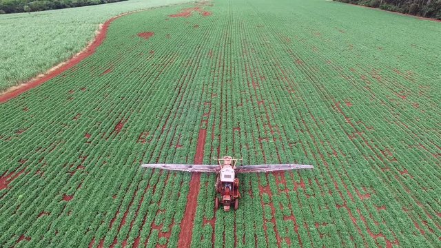 Aerial drone tilt of the old tractor pulverizing a peanut planting intial stage