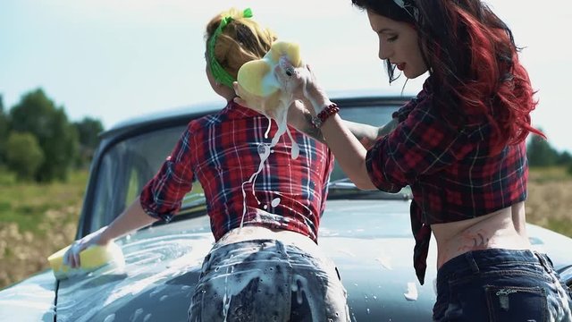 Sexy woman pouring foam on booty of another girl