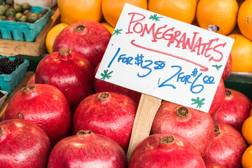 Pomegranates on Display with Handmade Sign with Name and Product in Farmers Market