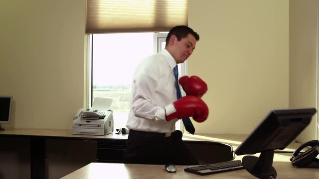 Office worker with boxing gloves hit computer