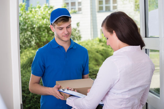 Woman Signing Receipt Of Delivery Package
