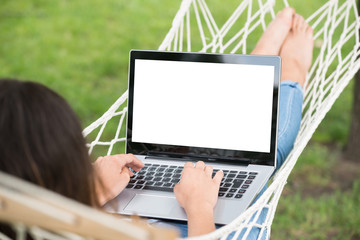 Woman Lying On Hammock Using Laptop