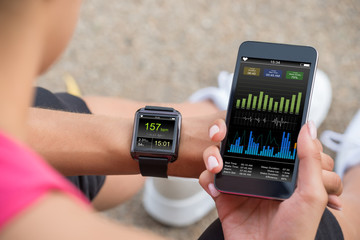 Running Female With Mobile Phone Connected To A Smart Watch