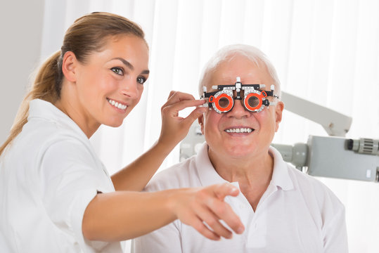 Female Optometrist Checking Patient's Vision With Trial Frame