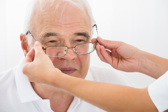 An Optician Helping Male Patient With New Eyeglasses
