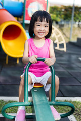 Fototapeta na wymiar Asian Chinese little girl on seesaw at playground