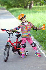 little girl with a bike and a bottle of water in hand