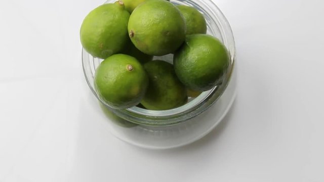 View of green limes in a container from above
