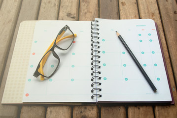 Notebook with a pencil and glasses.