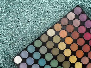 eye shadow palette on blue glitter background