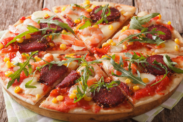 Pizza with salami, shrimp, mozzarella and arugula close-up. horizontal
