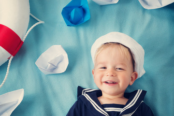 boy playing with paper ships