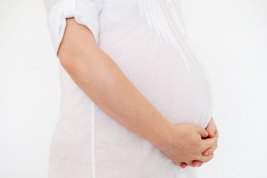 Stomach and hands pregnant woman on pure white background