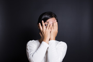 Woman hiding face laughing timid