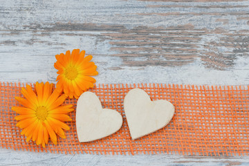 Obraz na płótnie Canvas Flower and wooden heart lying on wood