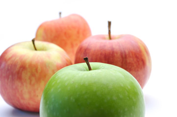 different concepts - green apple between red apples
