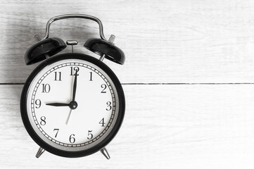 Vintage background with retro alarm clock 9pm am on wooden table