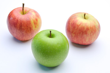 different concepts - green apple between red apples