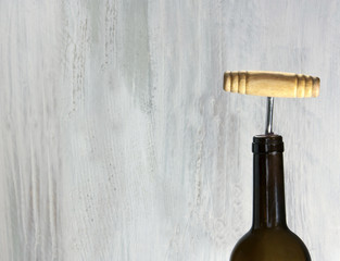 Bottle of wine with old-fashioned corkscrew and copyspace