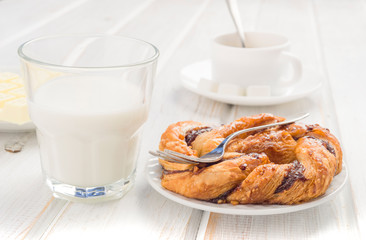 glass of milk and puff loop on wood