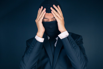 Businessman Wearing a Balaclava Thinking Corruption Plan but He