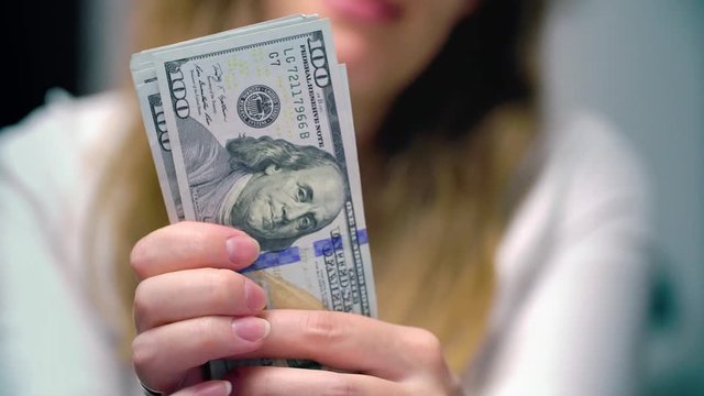 View of a woman Counting Many American 100 bills, Woman not happy about not having enough money
