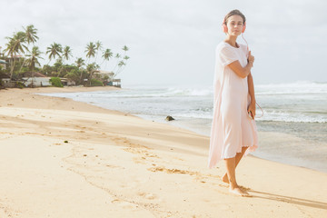 Fototapeta na wymiar Woman walking on the beach sand