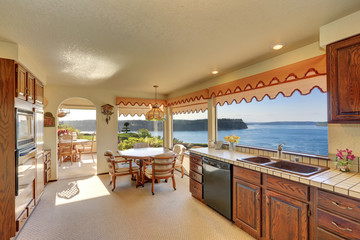 Kitchen and dining room interior with carpet flooring and arched entry
