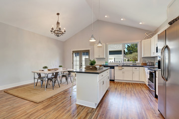Interior of kitchen and dining room with high vaulted ceiling.
