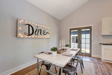 View of dining table with wooden top and metal chairs.