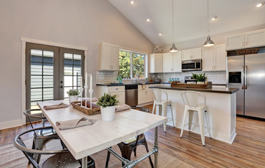 Interior of kitchen and dining room with high vaulted ceiling.