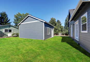 Fototapeta na wymiar Blue siding house with matching detached garage