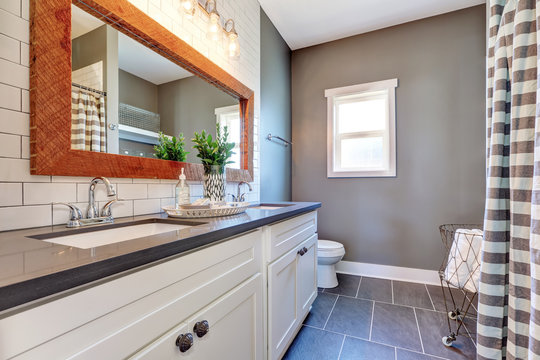 Elegant bathroom interior with tile floor and gray walls.